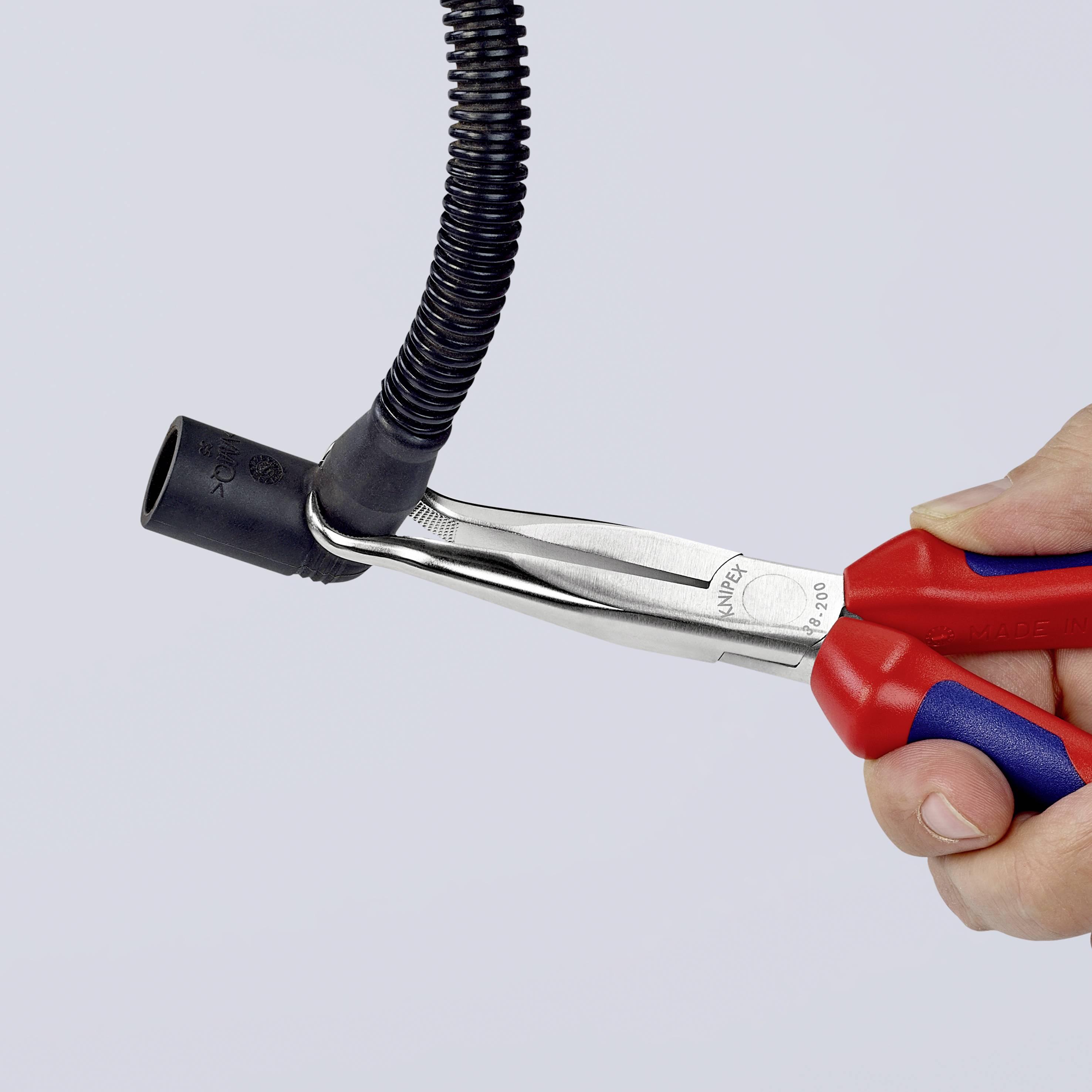 En hand håller en röd och svart slangklämma som griper om en svart flexibel slang.