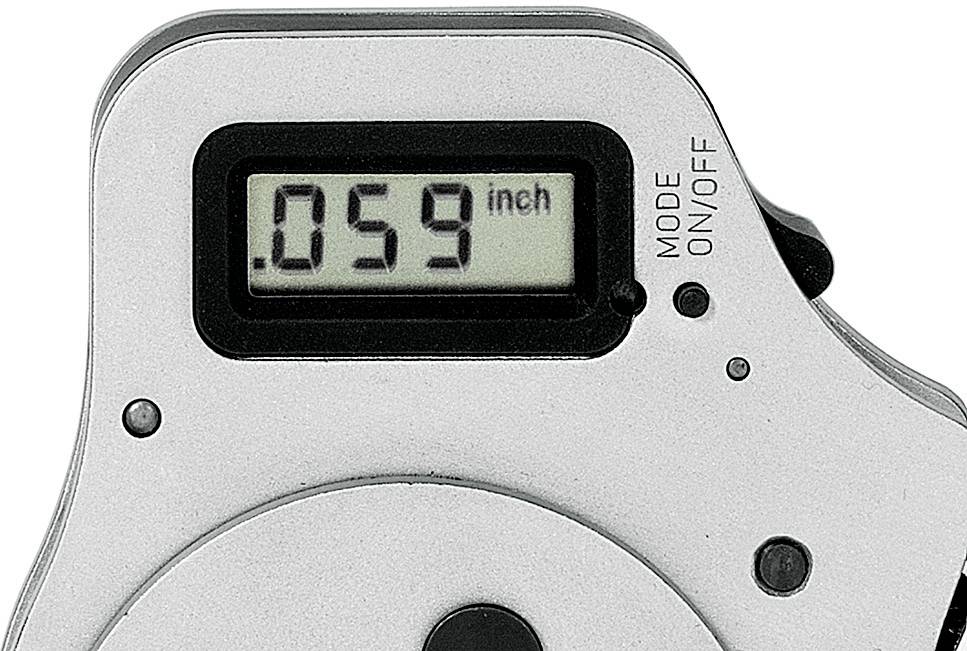 Mätinstrument med digitalvisning, står på '0,59 tum'. Strömbrytare märkt 'LÄGE' och 'PÅ/AV', metallhölje.