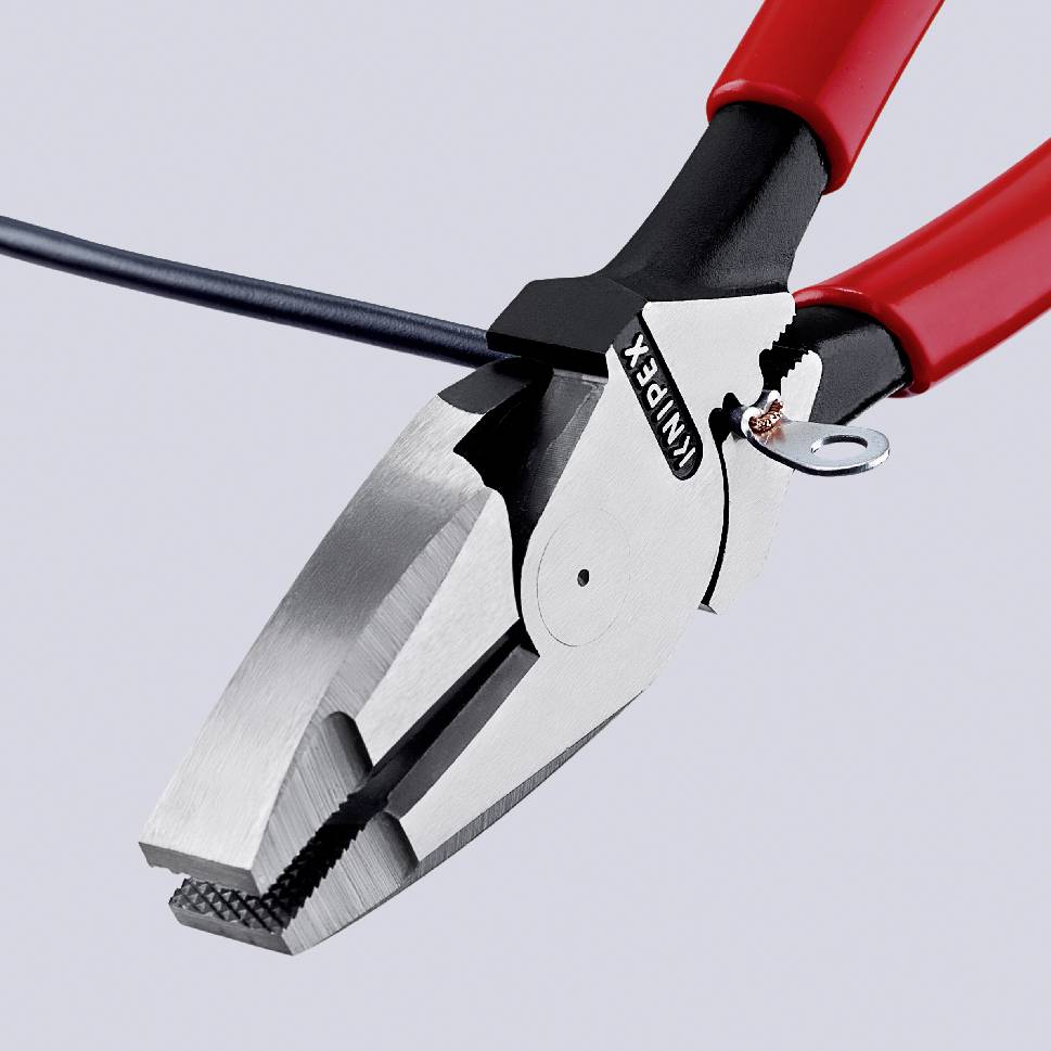 Röd tång håller fast en svart kabel. Huvudegenskap är det starka greppet på ljus bakgrund. Verktyg från Knipex.