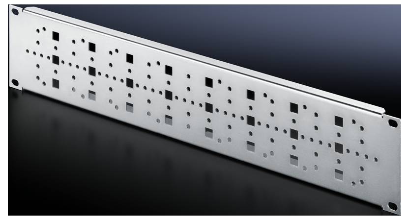 Metallplatta med rektangulära och kvadratiska hål, liggande på en mörk bakgrund. Används för elektroniska komponenter.