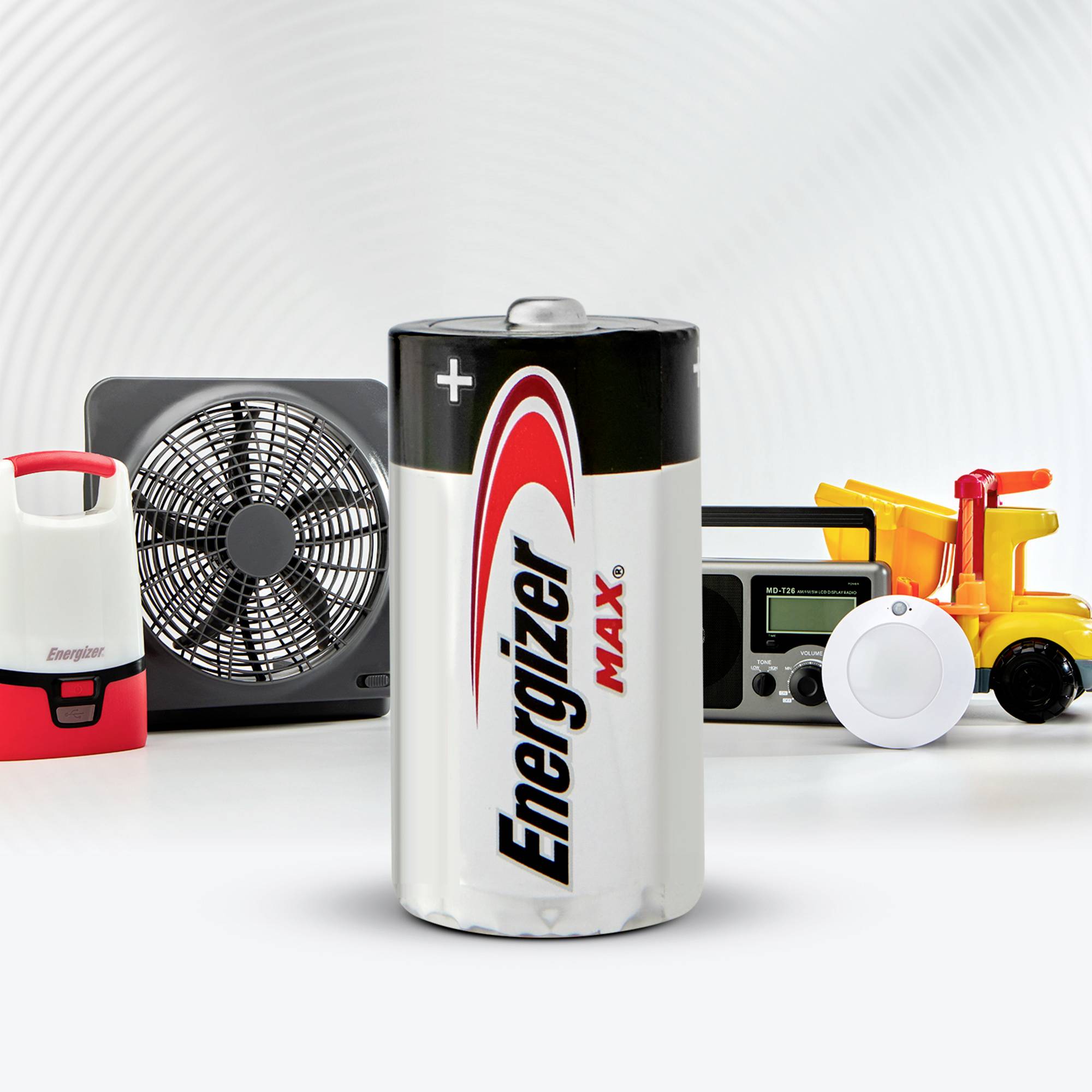 En Energizer-batteri i förgrunden med ytterligare hushållsapparater i bakgrunden, däribland en fläkt, en radio och en lampa.