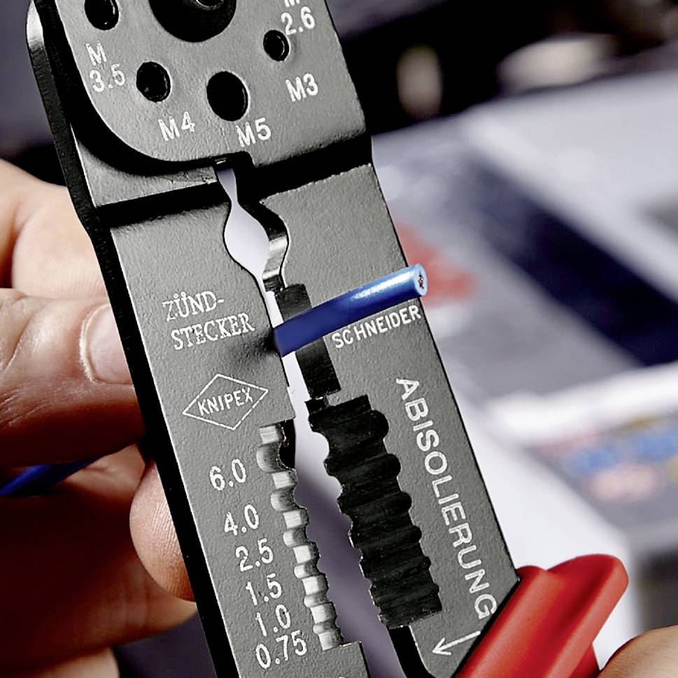 Hand håller en avisoleringstång med en blå trådklämma. Verktyget visar olika avisoleringsstorlekar och märkningar 'TÄNDSTIFT', 'KNIPEX', 'AVISOLERING'.