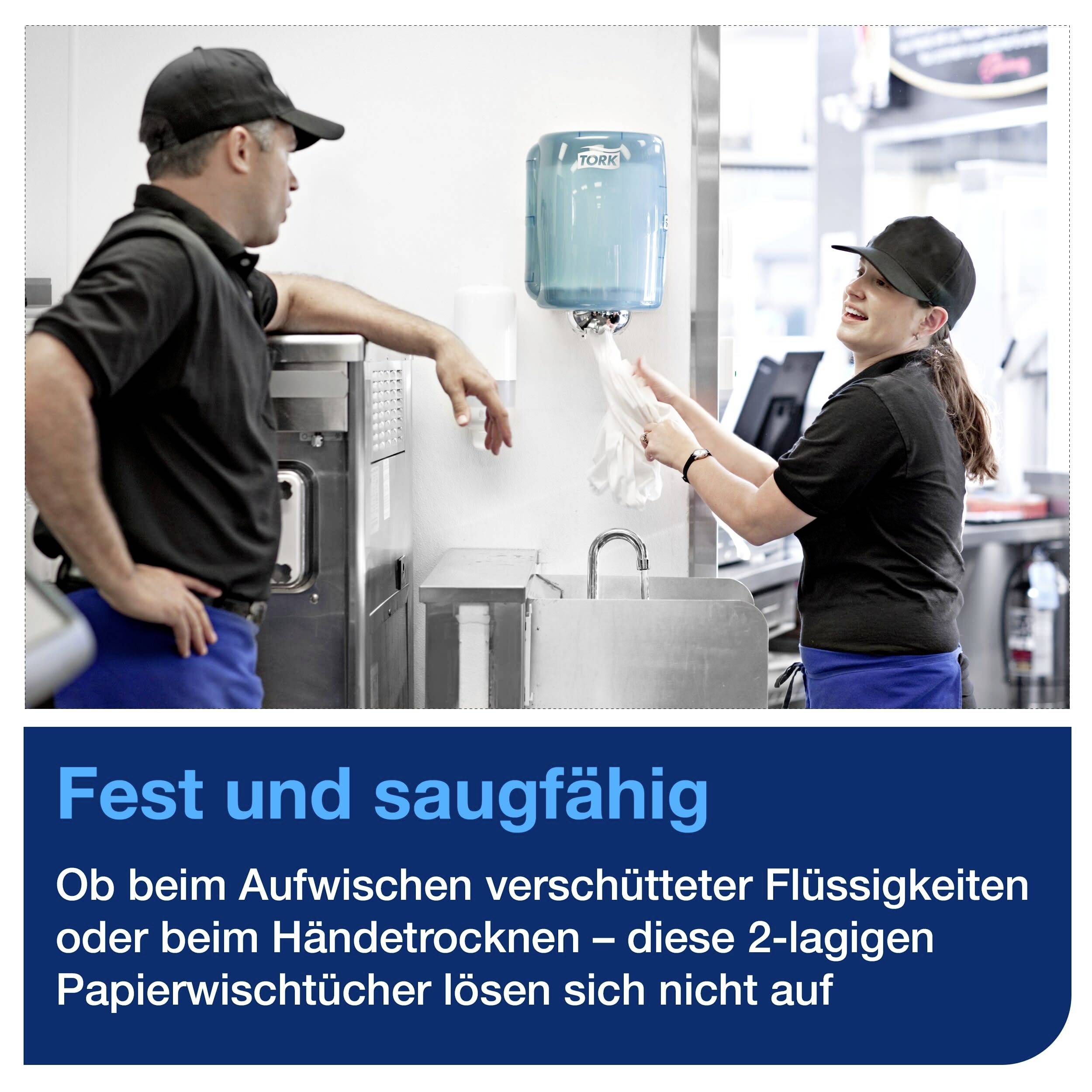 En man och en kvinna i arbetsuniform använder pappershanddukar från en automat i ett kök. Text: 'Fast och absorberande...'.