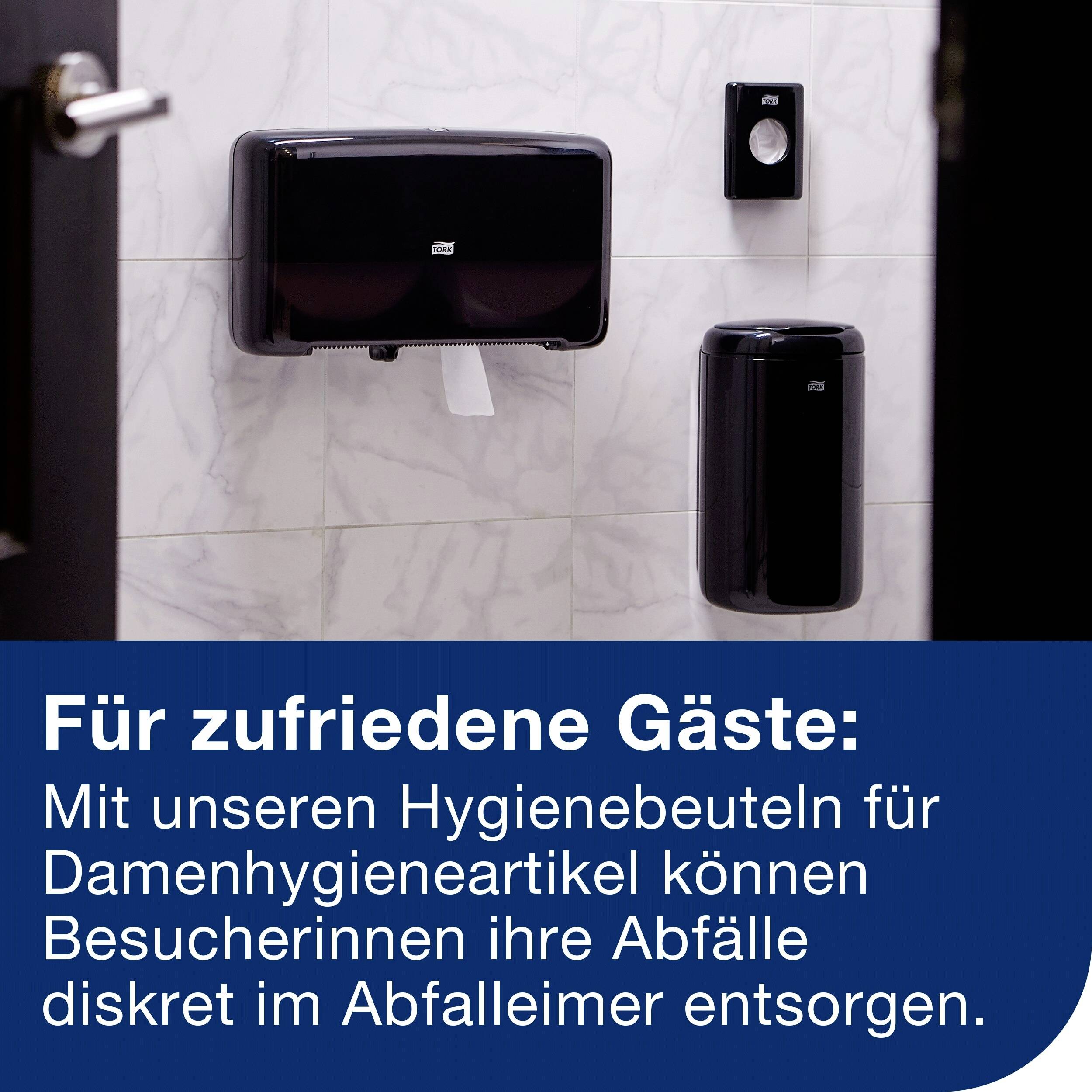 Dispenser för hygienväskor och avfallsbehållare på väggen i ett offentligt badrum med texten: För nöjda gäster.