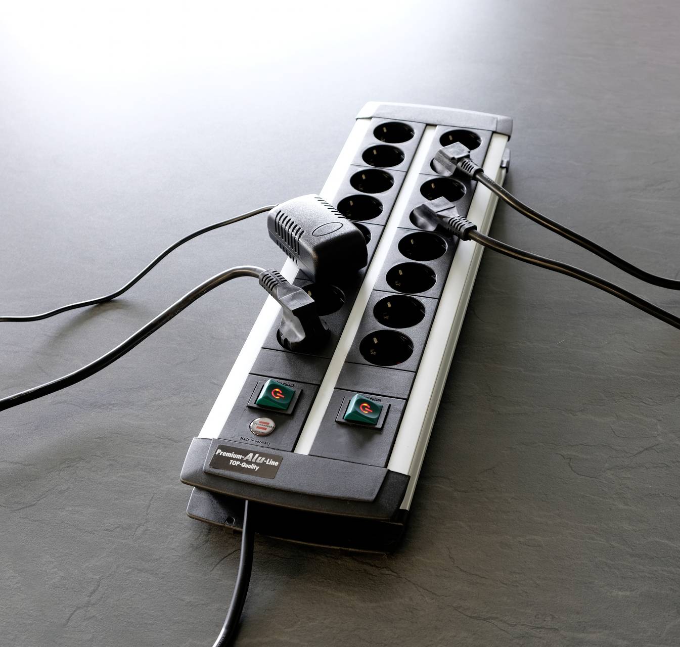 Grenuttag med flera anslutna kablar på en grå yta.