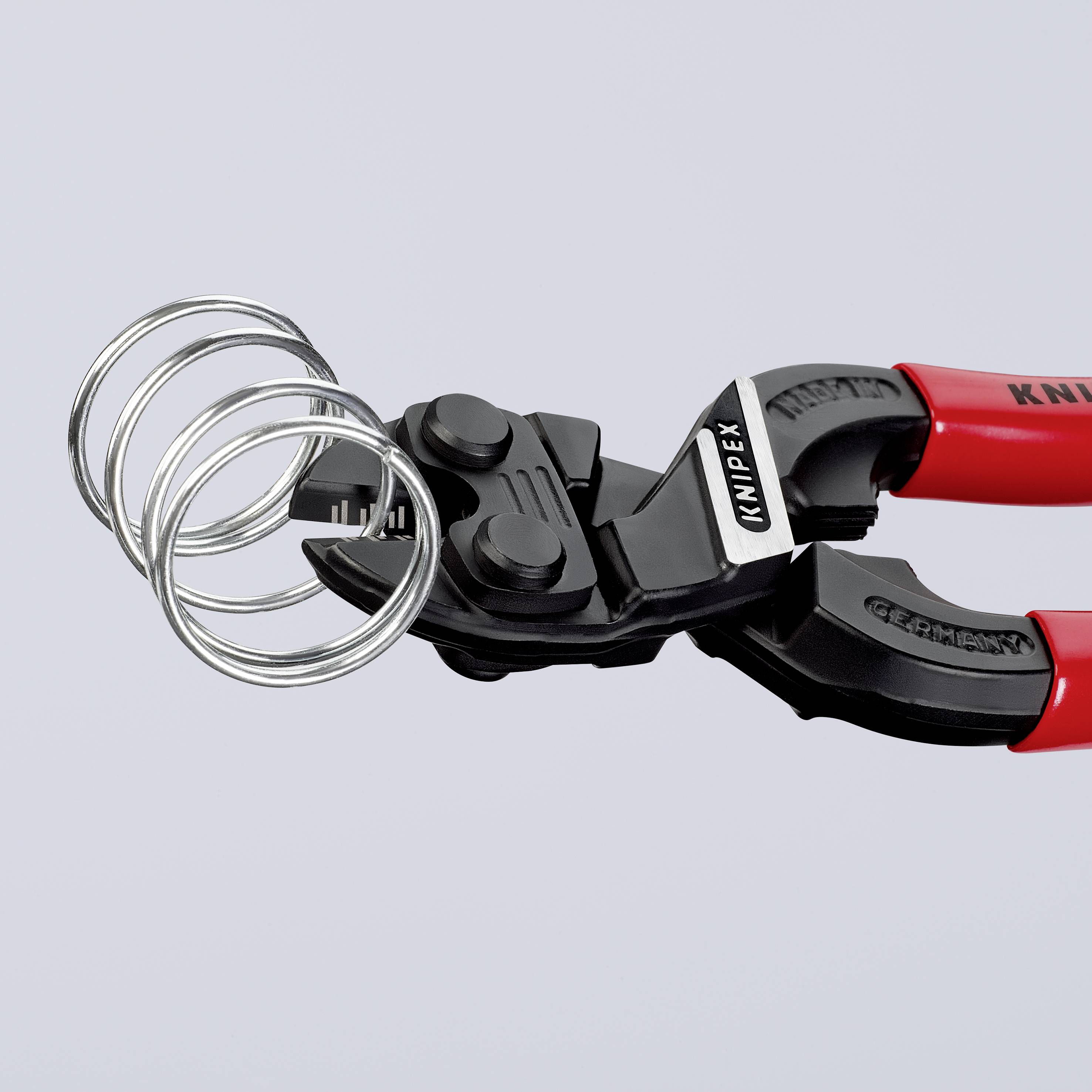 En röd bultsax från märket Knipex klipper tjocka metallringar. Den visar robusta skär för tunga arbeten.