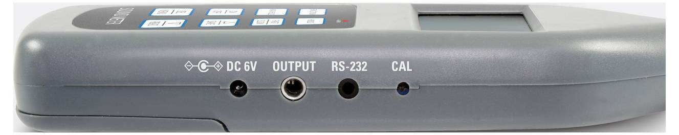 Baksidan av en elektronisk enhet med anslutningar: DC 6V, Utgång, RS-232 och Kalibrering (KAL).