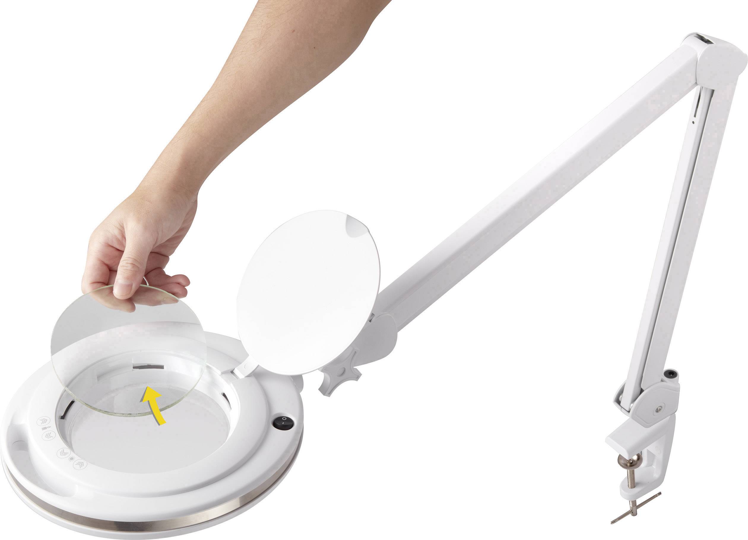En arm på en skrivbordslampa med en förstoringslins och ett lock. En hand lyfter locket för att rengöra eller byta ut glaset.