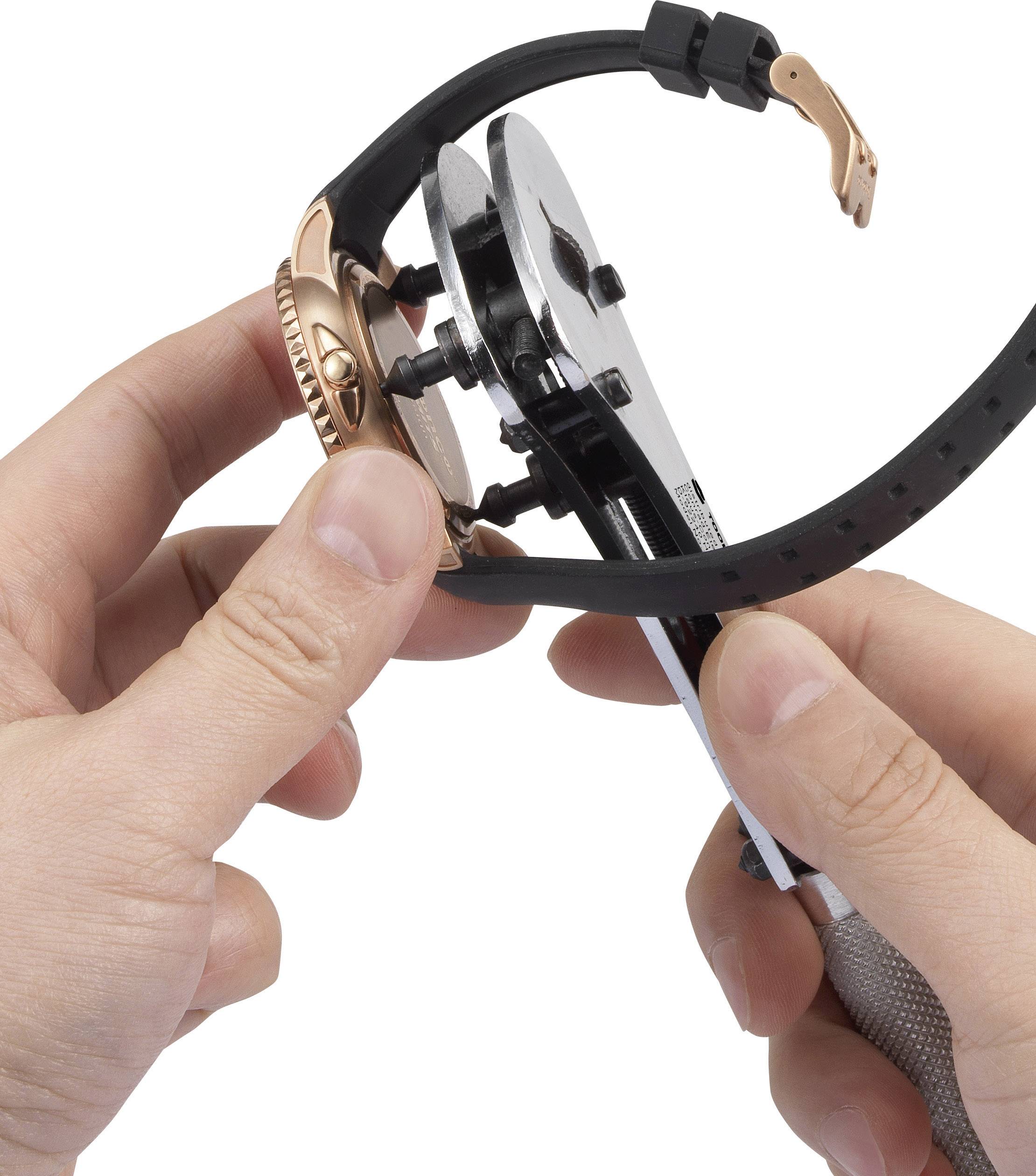 En person använder ett urverktygen för att ta bort eller justera en klockas armband.