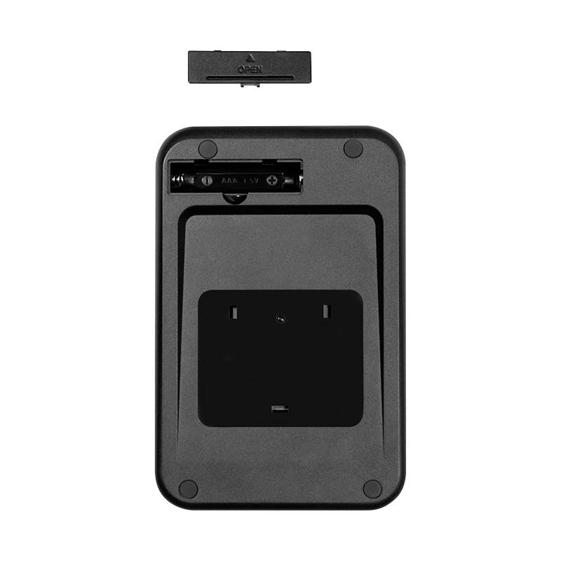 Svart batterifack på en elektronisk enhet, öppnat med synlig AAA-batteriplats. Locket liggande bredvid.