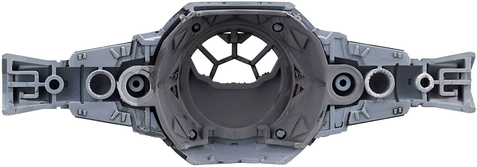 En grå, metalliskt verkande komponent med ett centralt hål och symmetriska, detaljerade strukturer. Påminner om en maskindel eller ett science fiction-design.
