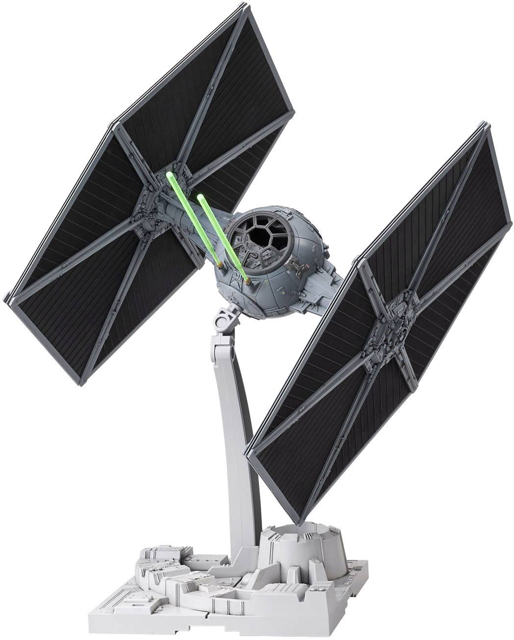 En modell av en TIE Fighter från 'Star Wars' med svarta vingar och detaljer på en grå sockel.