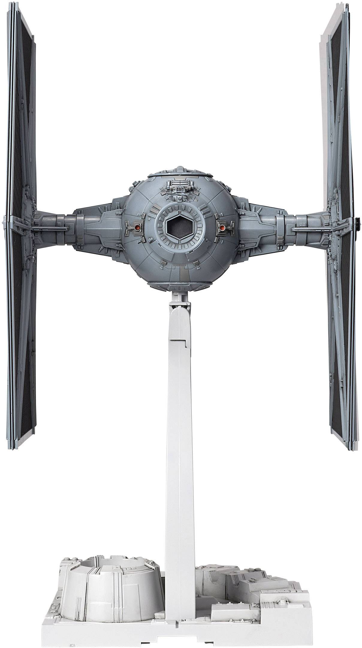 En modell av ett rymdskepp med två vertikala vingar, ett centralt sfäriskt cockpit och ett vitt stativ som stöd.