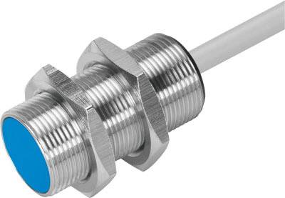 En cylindrisk närhetssensor med metallgänga och blå sensoryta. Fäst vid en kabel.