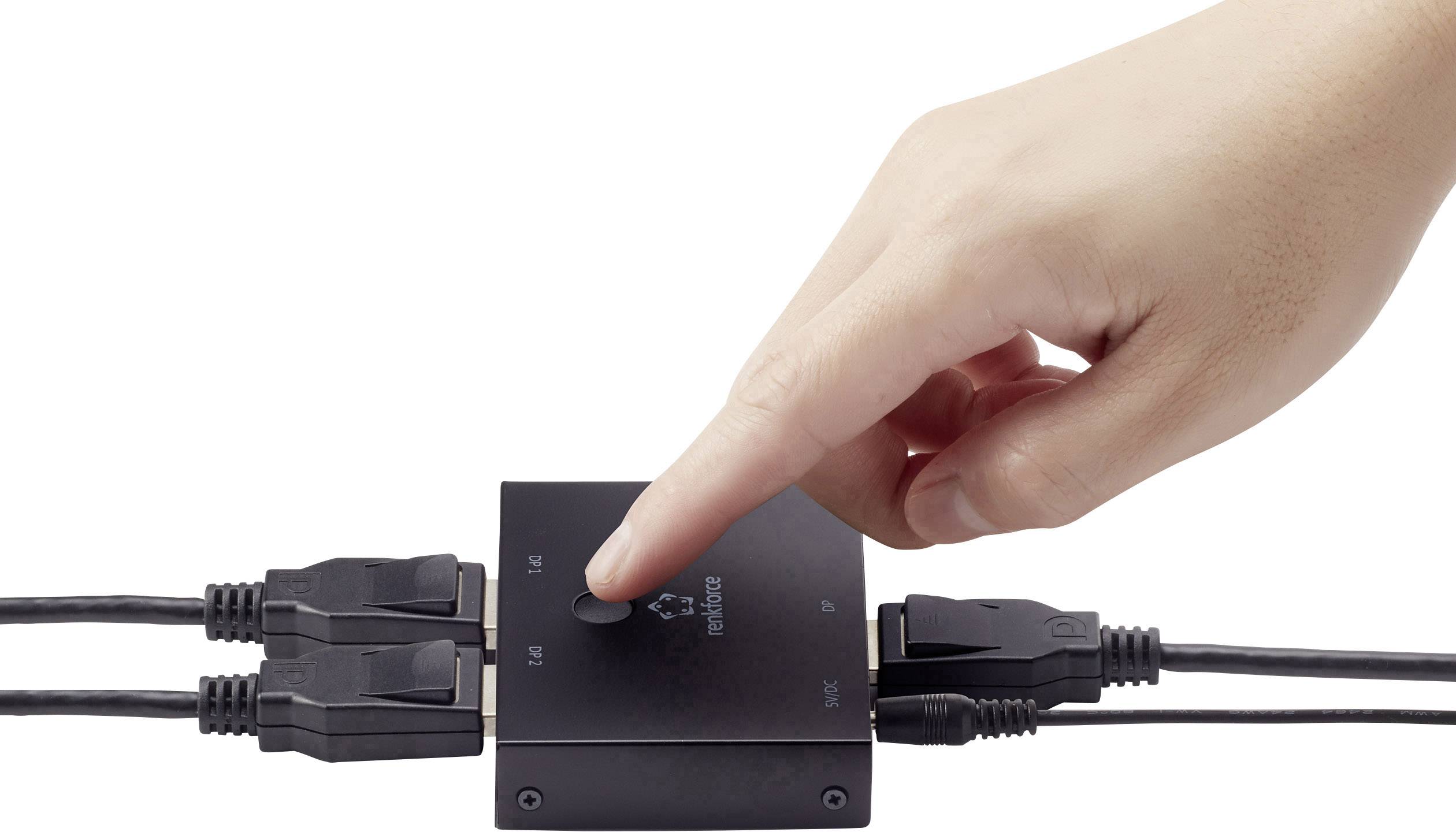 En hand trycker på knappen på en HDMI-switch som är ansluten till flera HDMI-kablar.