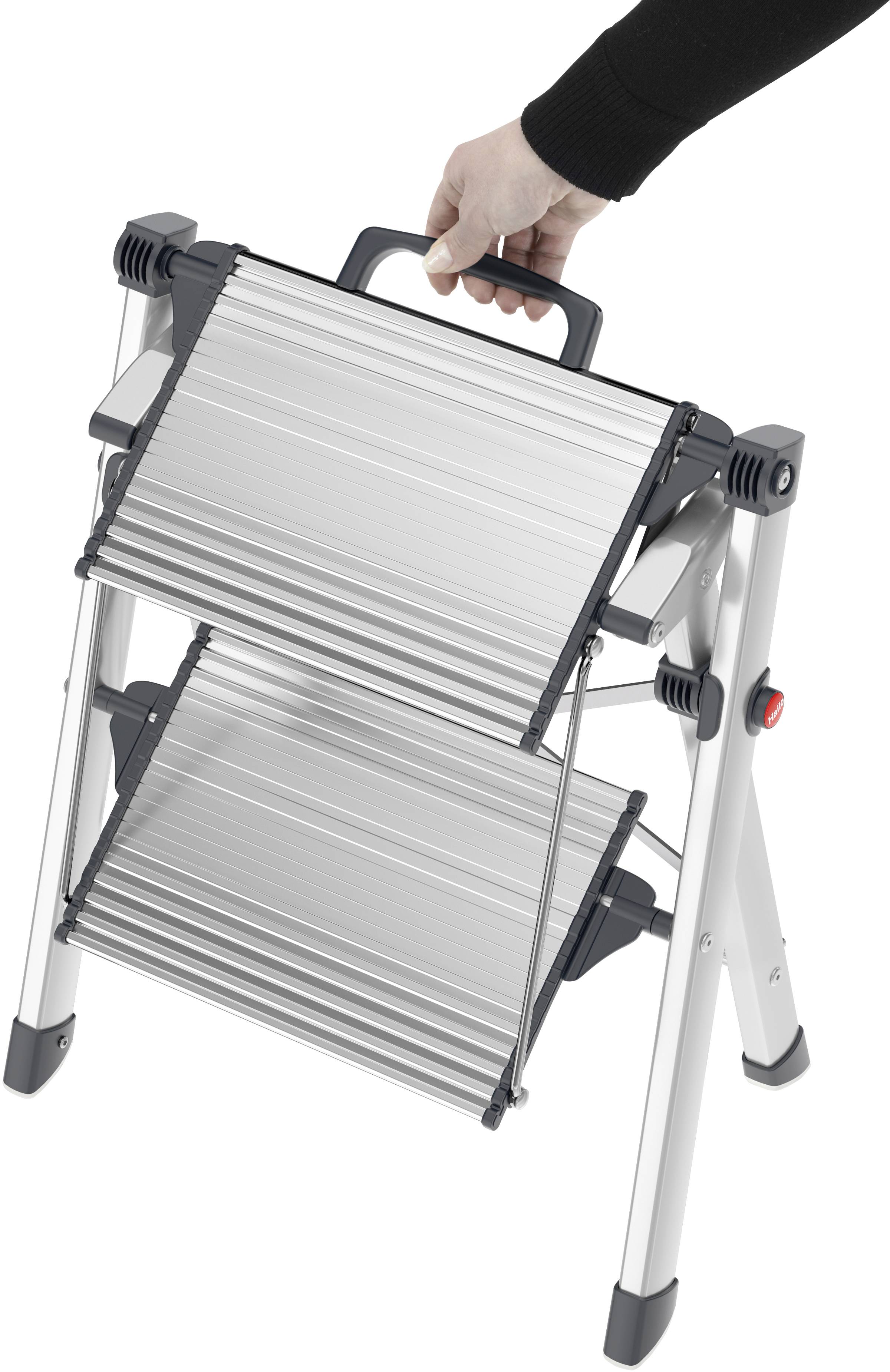 En person håller en hopfällbar, silver stege med ett handtag. Stegen har två steg och en svart ram.
