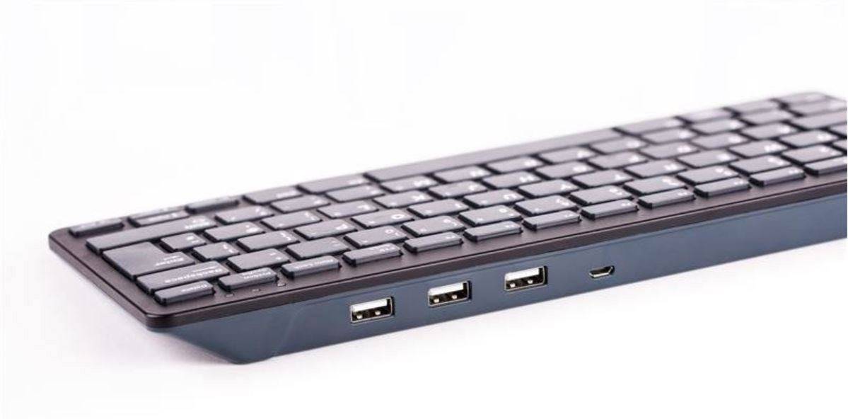 Svart trådlös tangentbord med tre USB-portar och en Micro-USB-port på sidan, placerad mot en vit bakgrund.
