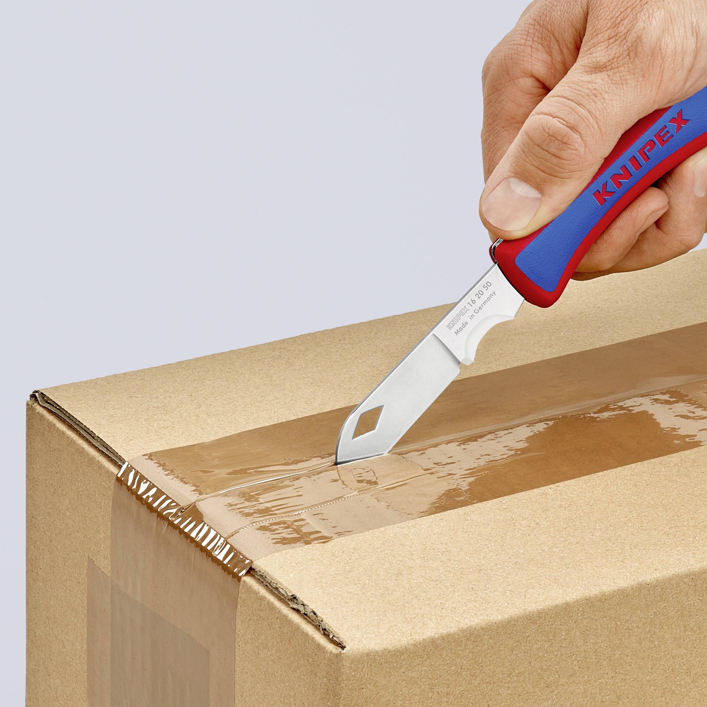 En hand använder en blå-röd kniv för att öppna en kartong.