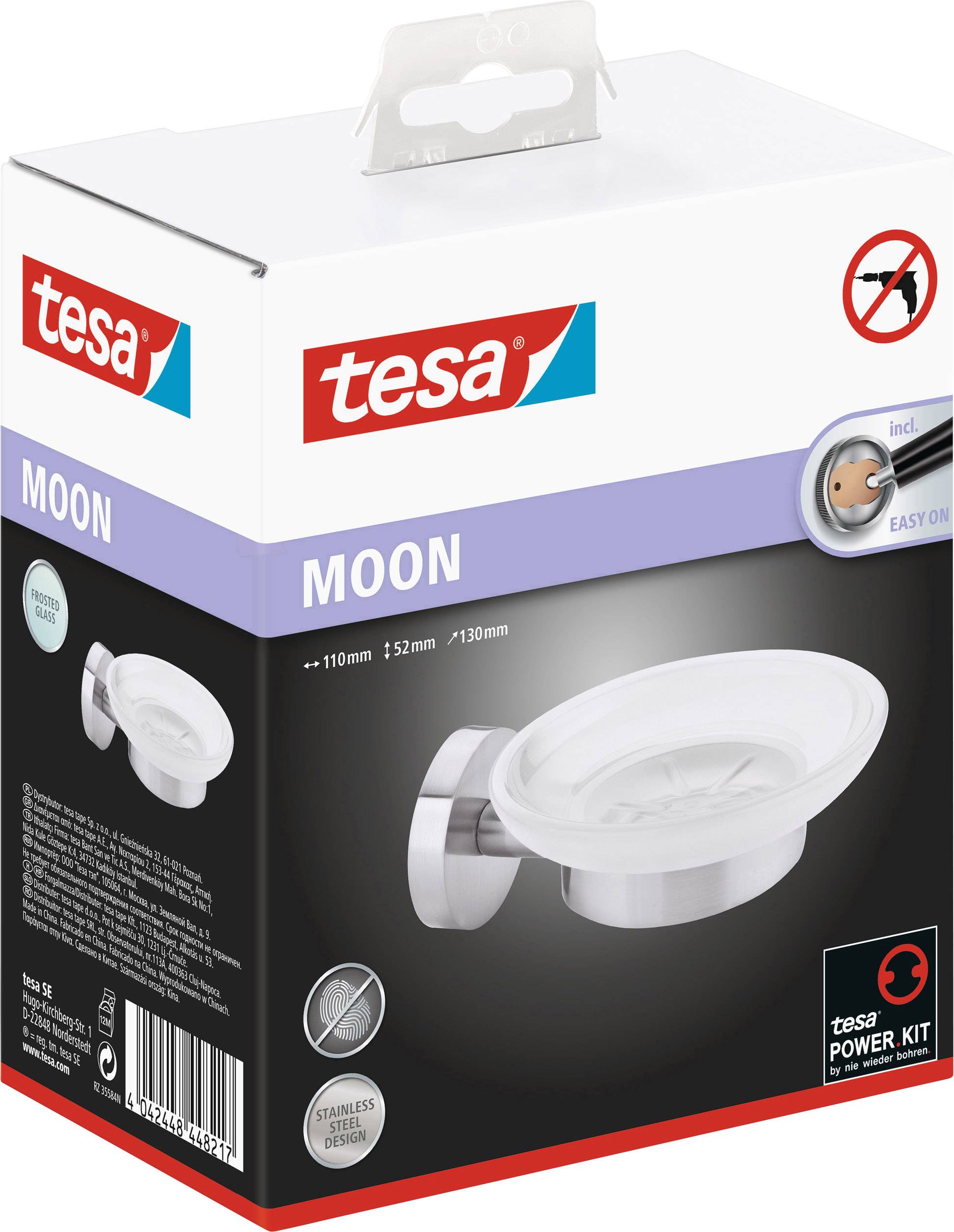 En rektangulär förpackning med logotypen 'tesa' visar en tvålkopp i rostfritt stål. Text på förpackningen: 'MOON', 'Stainless Steel Design'.