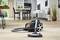 Dammsugare på parkettgolv i ett modernt kök, med matbord i bakgrunden. Apparaten är avstängd och används inte.