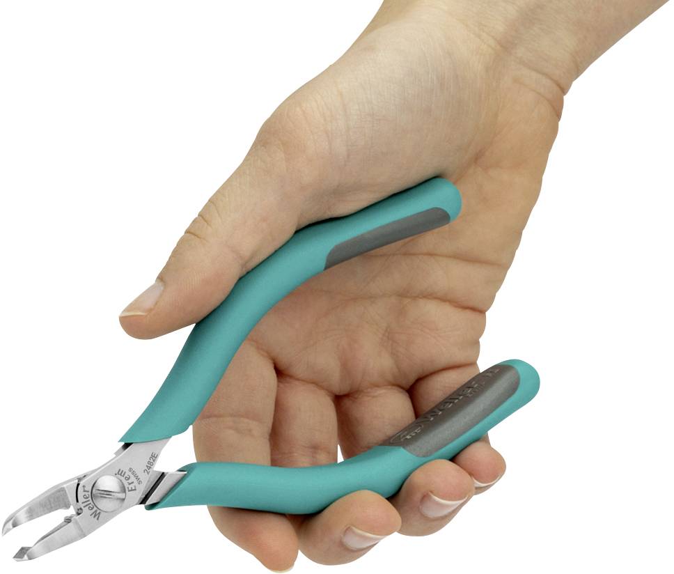 En hand håller en liten sidavbitare med gröna handtag, lämplig för att klippa trådar eller fina material.