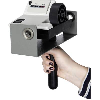 Hand håller en enhet för att mäta längd. Räkneverk visar måttenheter. Robust konstruerad med ergonomiskt grepp.