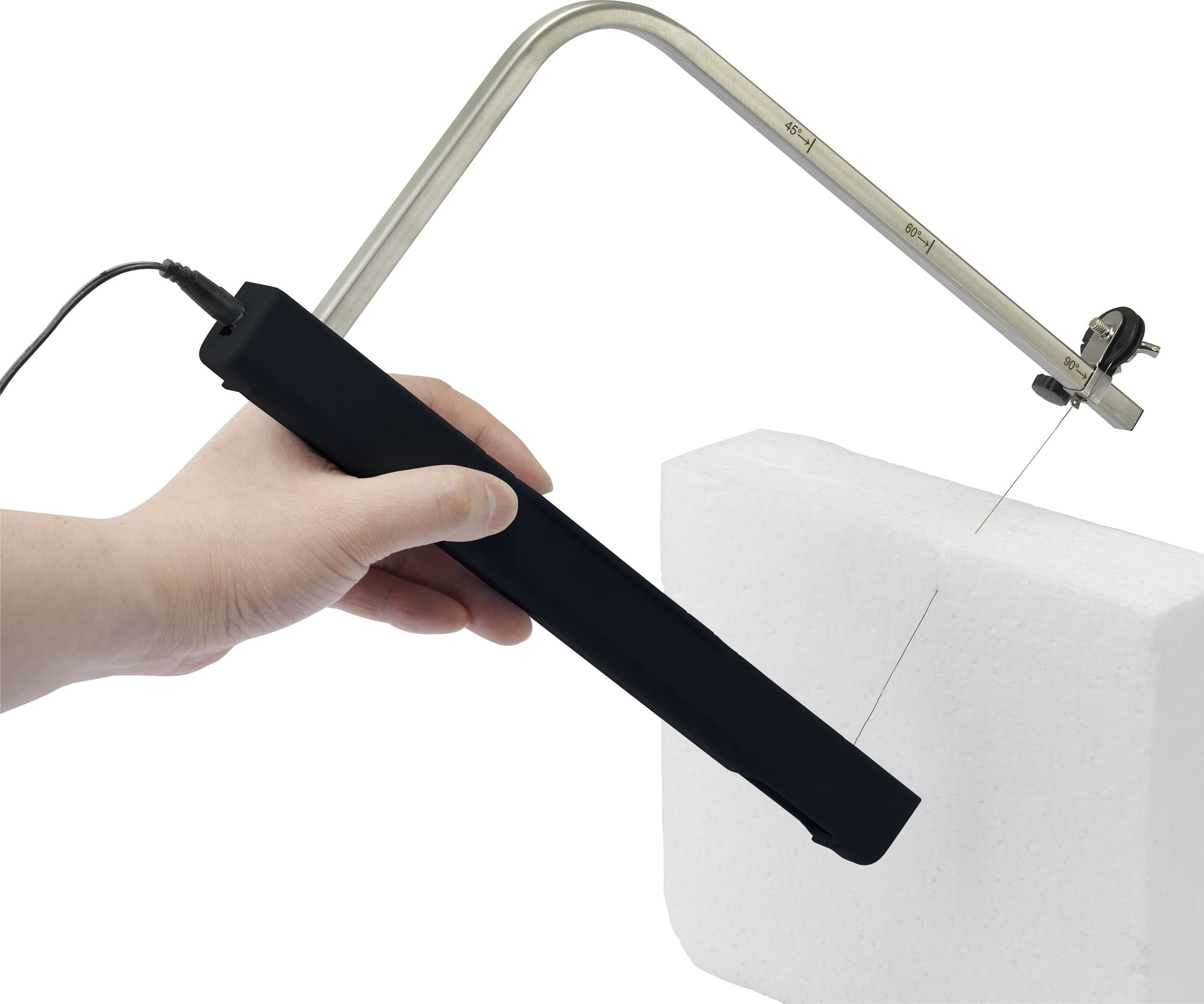 En hand håller en elektrisk skärapparat med en tunn tråd som klipper skum.