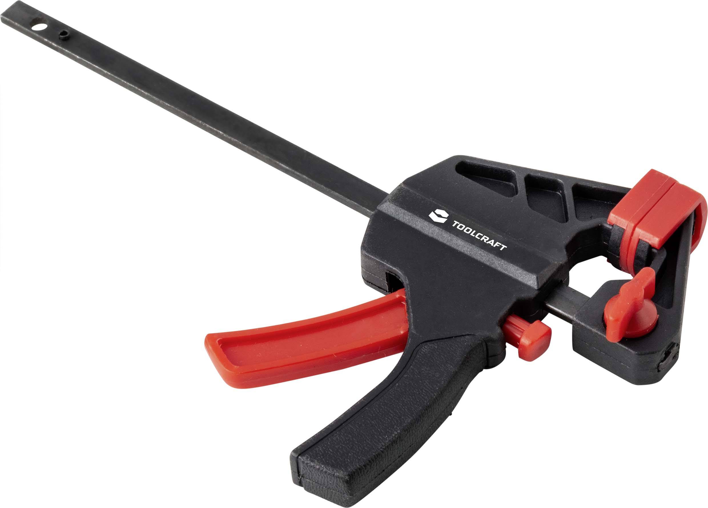 En svart skruvtving med röd handtag och röda spännbackar, från märket Toolcraft. Lämplig för att hålla fast objekt.