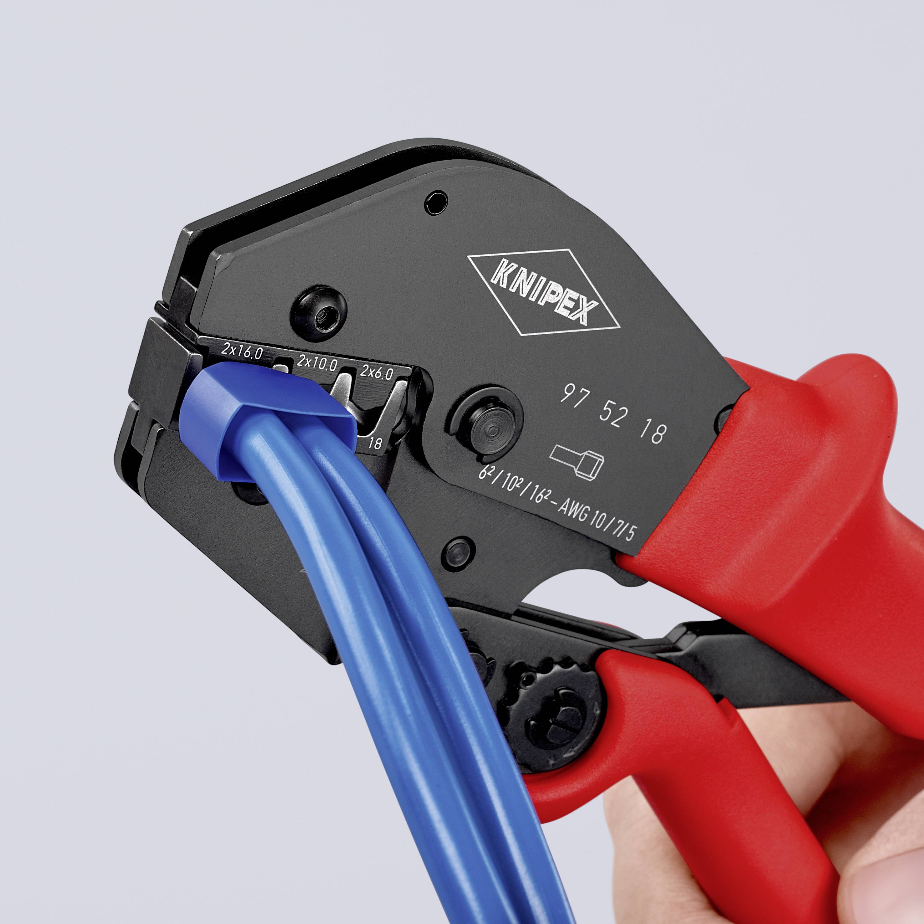 En hand håller en röd crimptång som är på väg att bearbeta blå ledningar. Tången är en Knipex-modell.