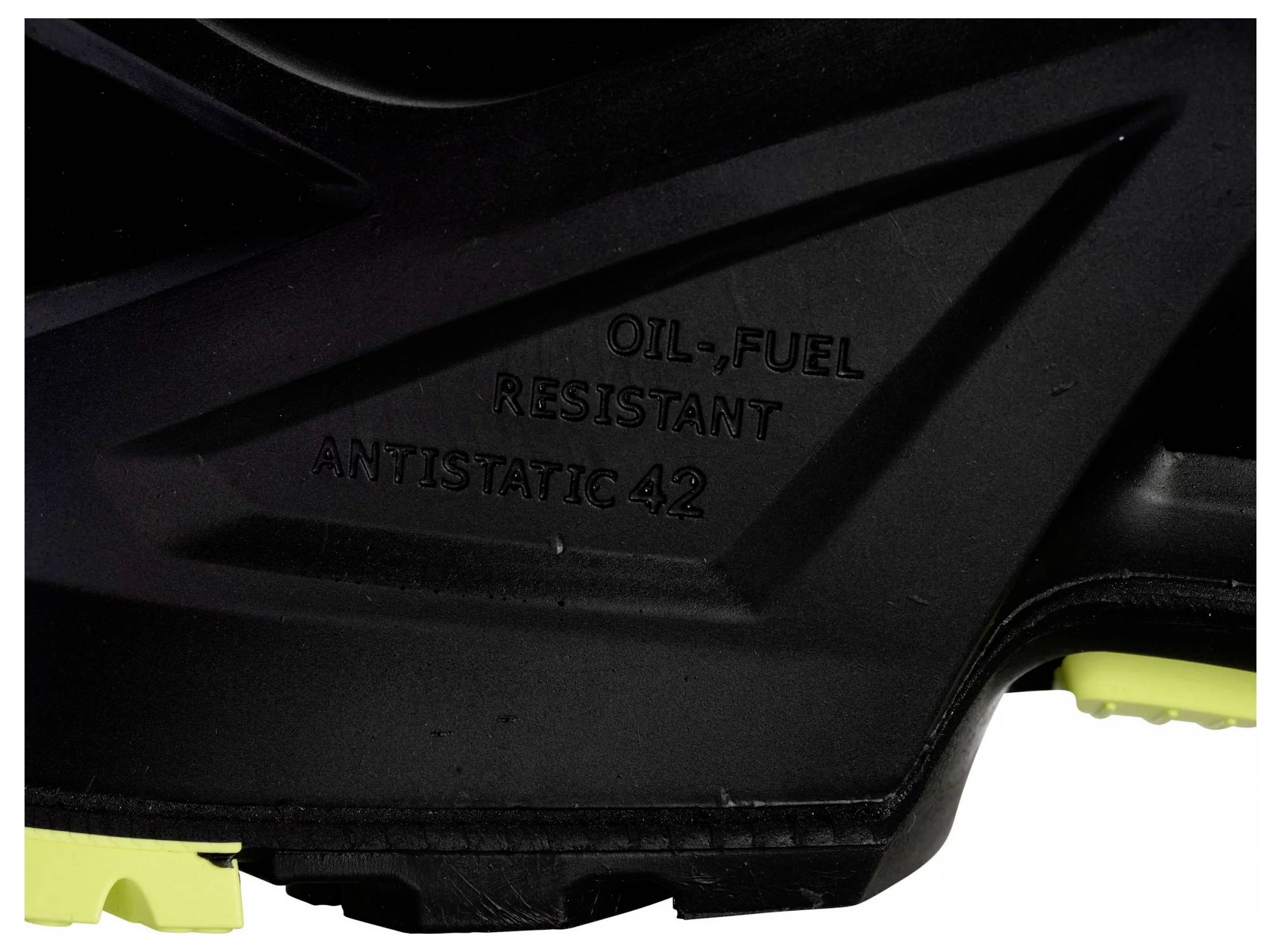 Svart-gul sko med texten 'OIL, FUEL RESISTANT ANTISTATIC 42', fokuserad på sulan.