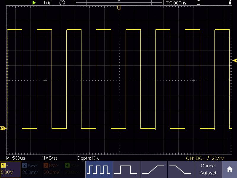 Oscilloskop-display: Gul rektangulär våg med konstant mönster, tidaxel i mikrosekunder, spänningsskala 5 volt.