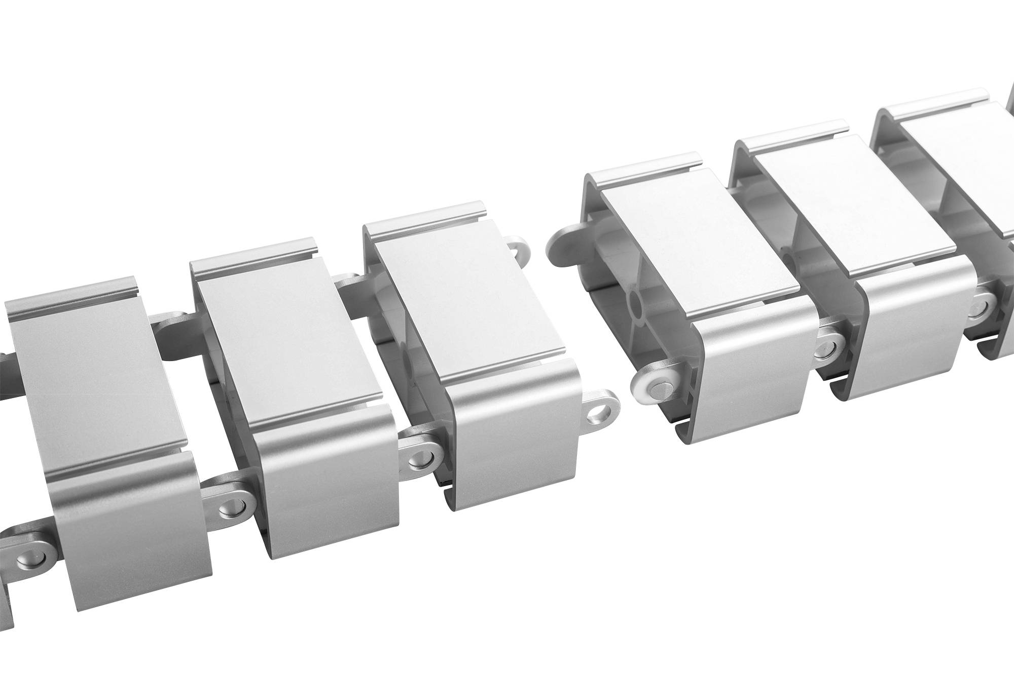 Kabelsläpssystem bestående av silverfärgade plastdetaljer som är sammanlänkade för att säkert leda och skydda kablar.