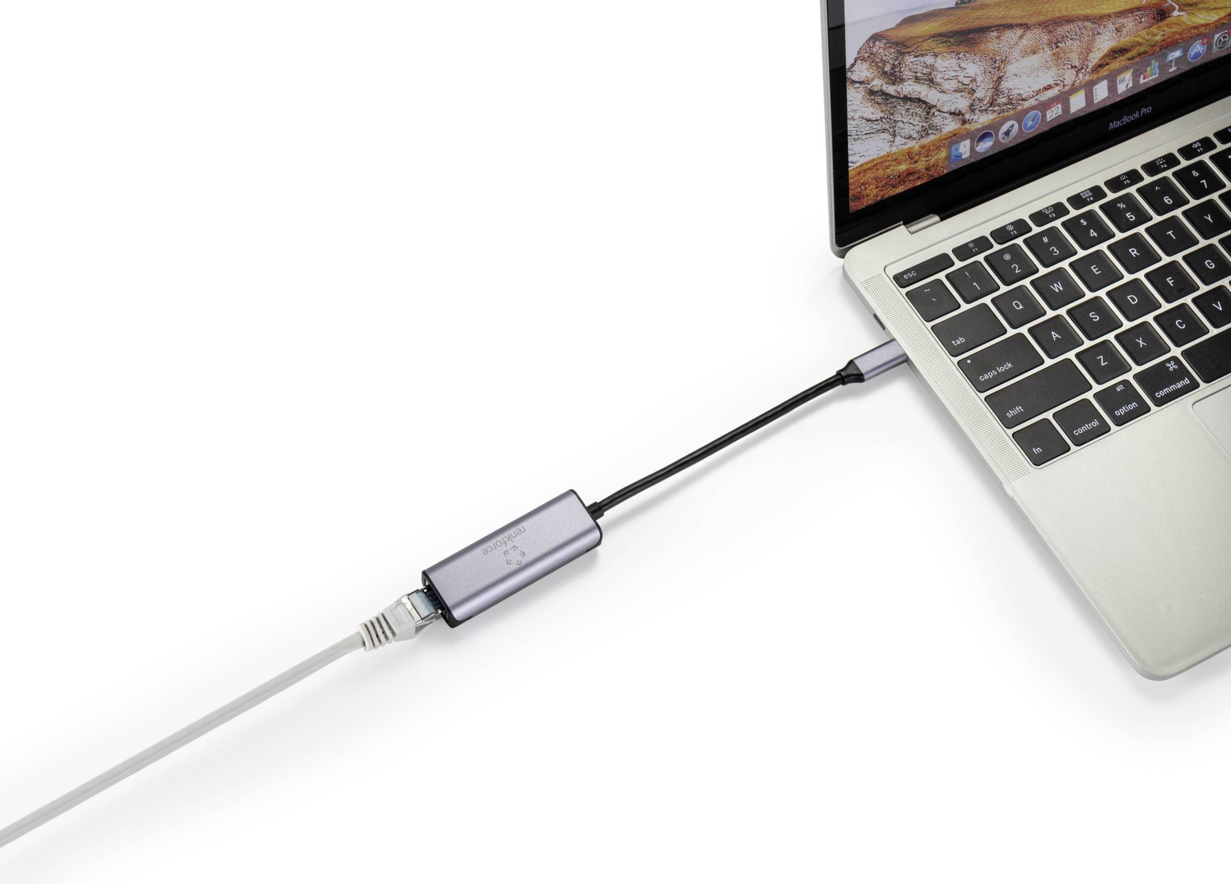 En laptop är ansluten via en USB-adapter med en Ethernet-kabel. MacBooken visar en sandbakgrund på skärmen.