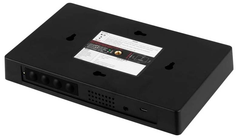 Svart väggmonterbar elektronisk enhet med frontportar, indikatorlampor och en instruktionsetikett på ovansidan; vingelperspektivvy på vit bakgrund.