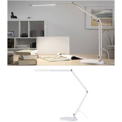 En vit skrivbordslampa med justerbar arm står på ett bord, omgiven av böcker. I bakgrunden syns en bokhylla.