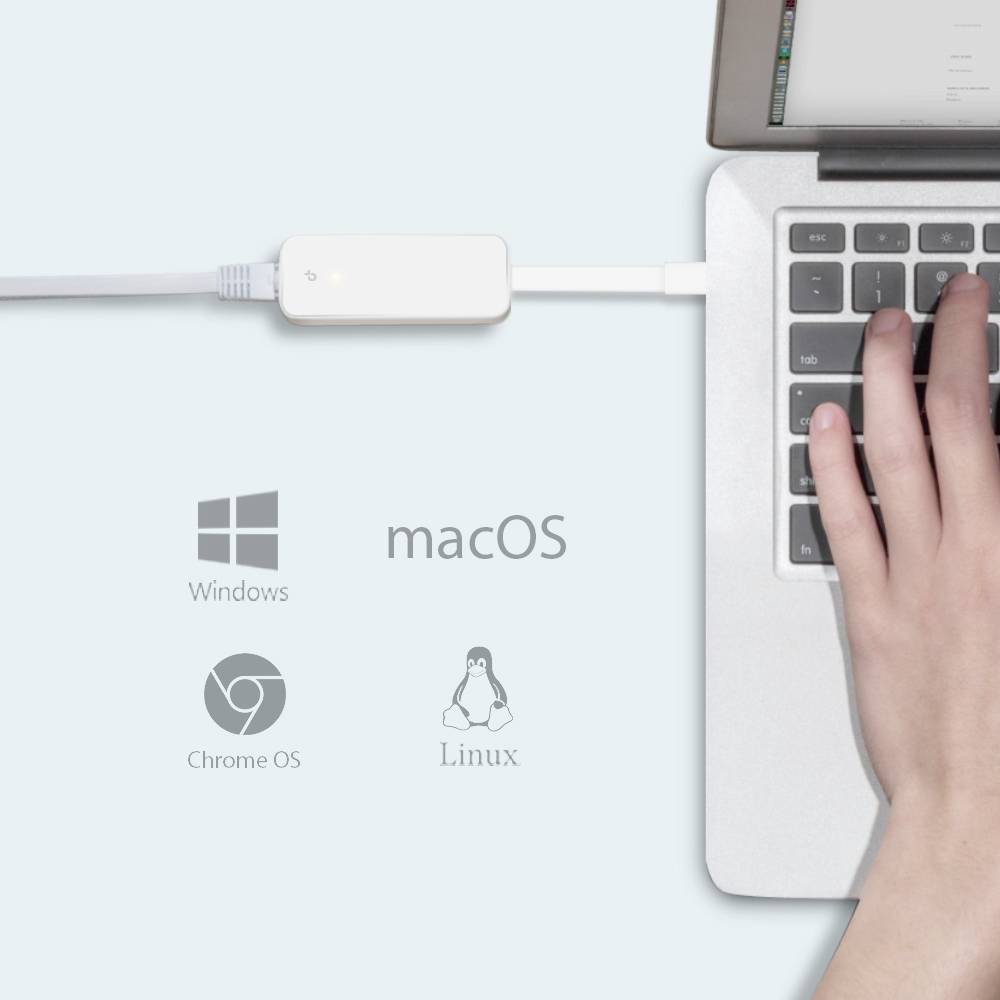 En hand som trycker på en laptops tangentbord. Laddare ansluten. Logotyper för Windows, macOS, Chrome OS och Linux är synliga.