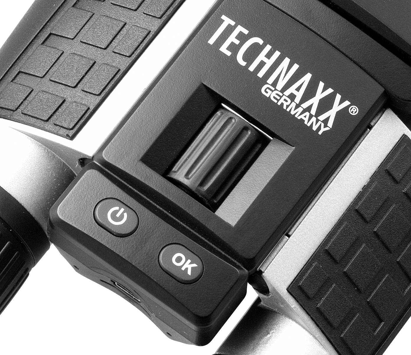 Närbild av en del av en elektronisk enhet märkt 'TECHNAXX GERMANY', med ett hjul och två knappar: 'Power' och 'OK'.