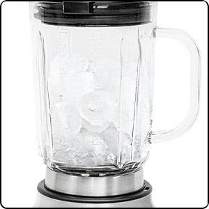 En glasbehållare till en mixer fylld med isbitar, monterad på ett rostfritt stativ.