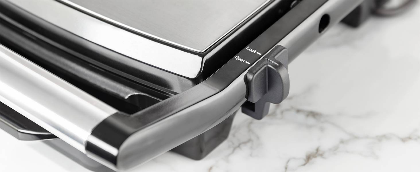 En elektrisk grill på en marmorarbetsskiva visar en temperaturregulator på sidan och blanka rostfria ytor.