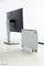 Två skärmar på ett bord: till vänster en stor skärm, till höger en tunn skärm i ett stående fäste. Båda är grå.