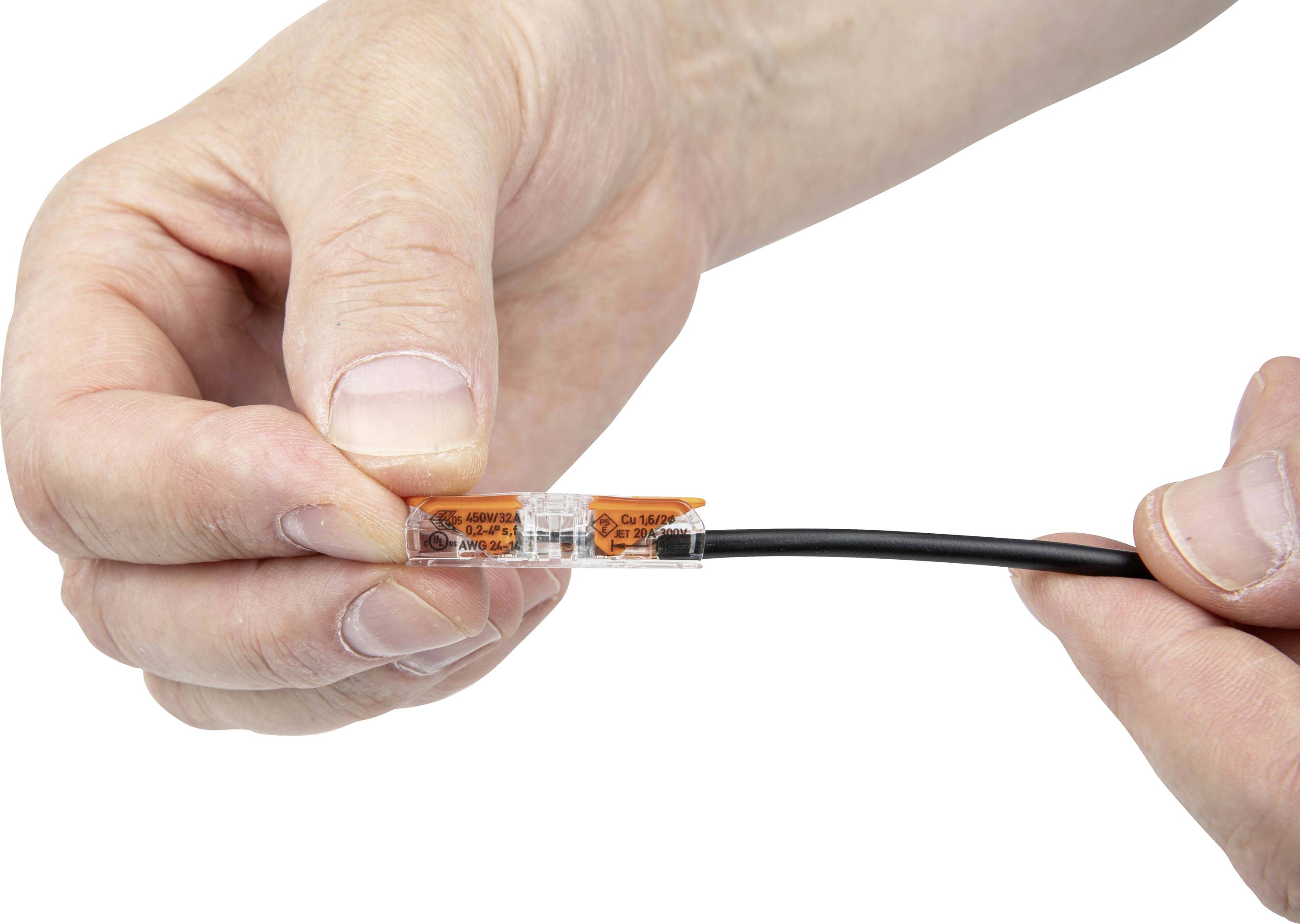 Närbild av två händer som håller en liten, transparent kontakt som kläm fast ett svart kabel.