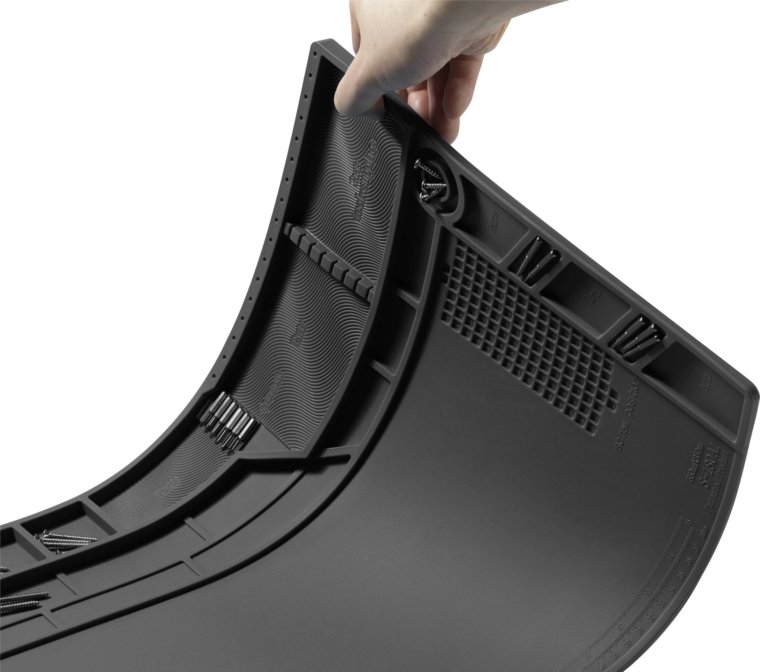 En hand håller en svart, flexibel bilmatta med halkfri design och strukturerade detaljer för bättre grepp.