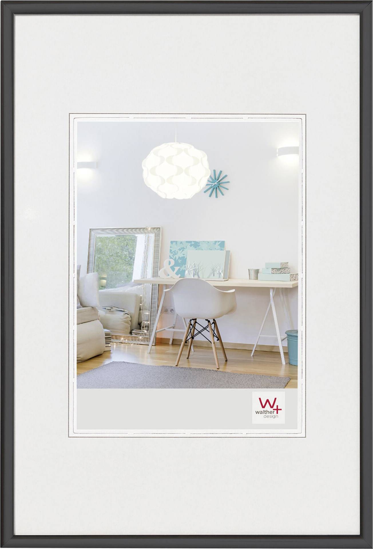 Ett modernt, ljust arbetsrum med ett vitt skrivbord, en stol och en stor spegel. Konstverk och lampa i bakgrunden.