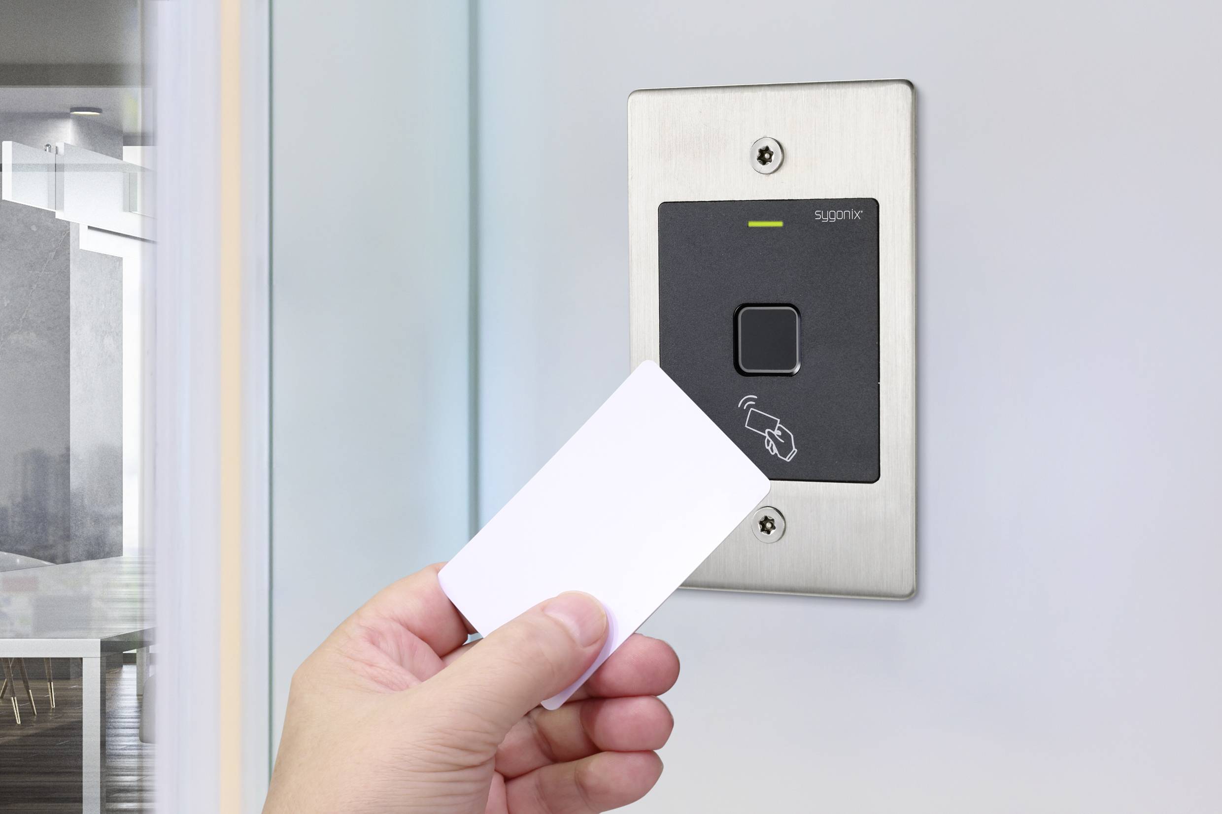 En hand håller ett kort framför ett modernt accesskontrollsystem vid en kontorsdörr. Systemet visar en läsare och en lampa.