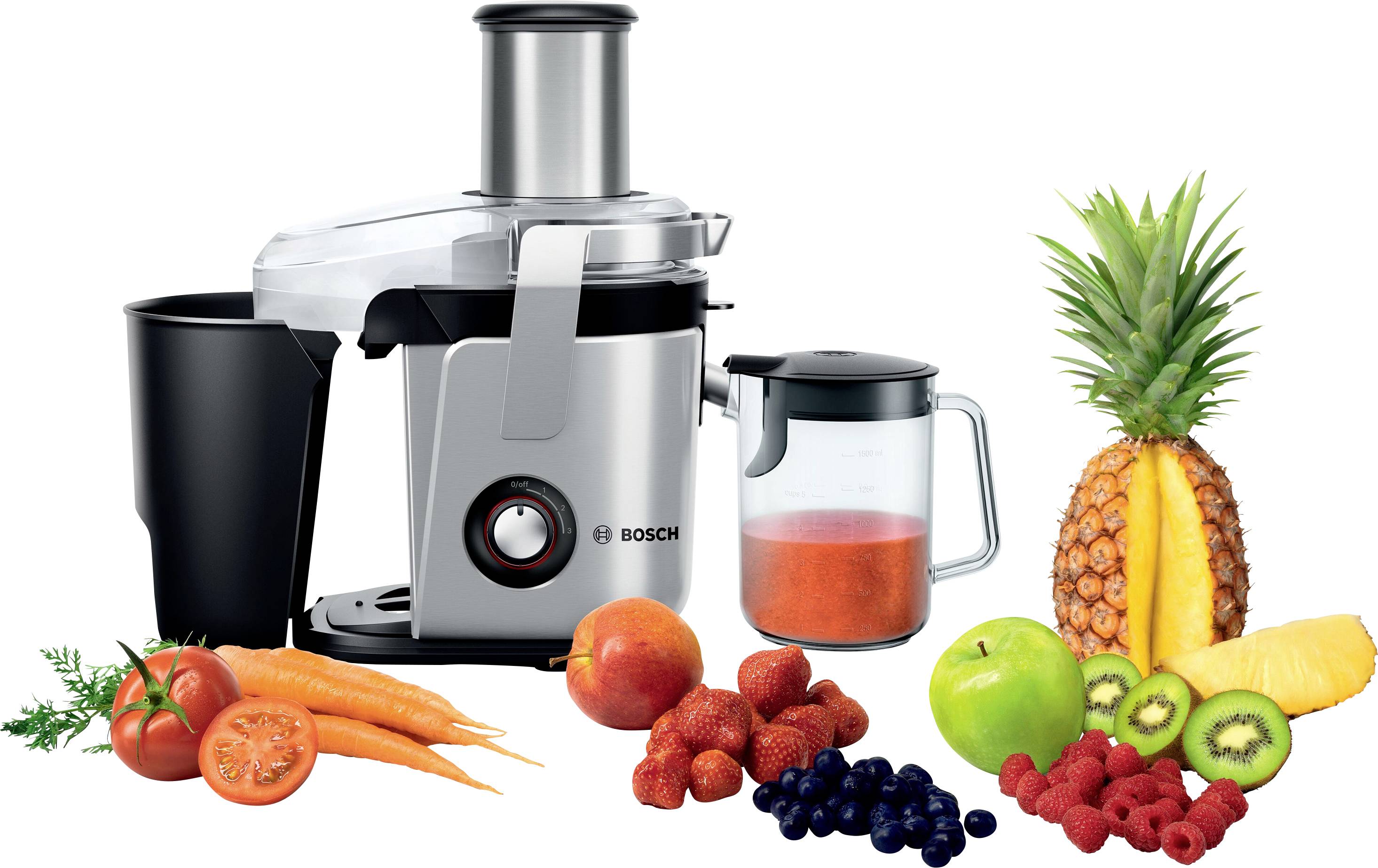 En juicermaskin bredvid färska frukter och grönsaker som ananas, morötter, äpplen och bär; apparaten är redo att bereda juice.