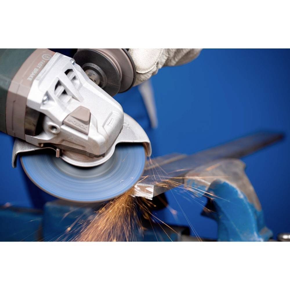 En arbetare sliper metall med ett elverktyg. Gnistor sprider sig från slipskivan medan metallen bearbetas.
