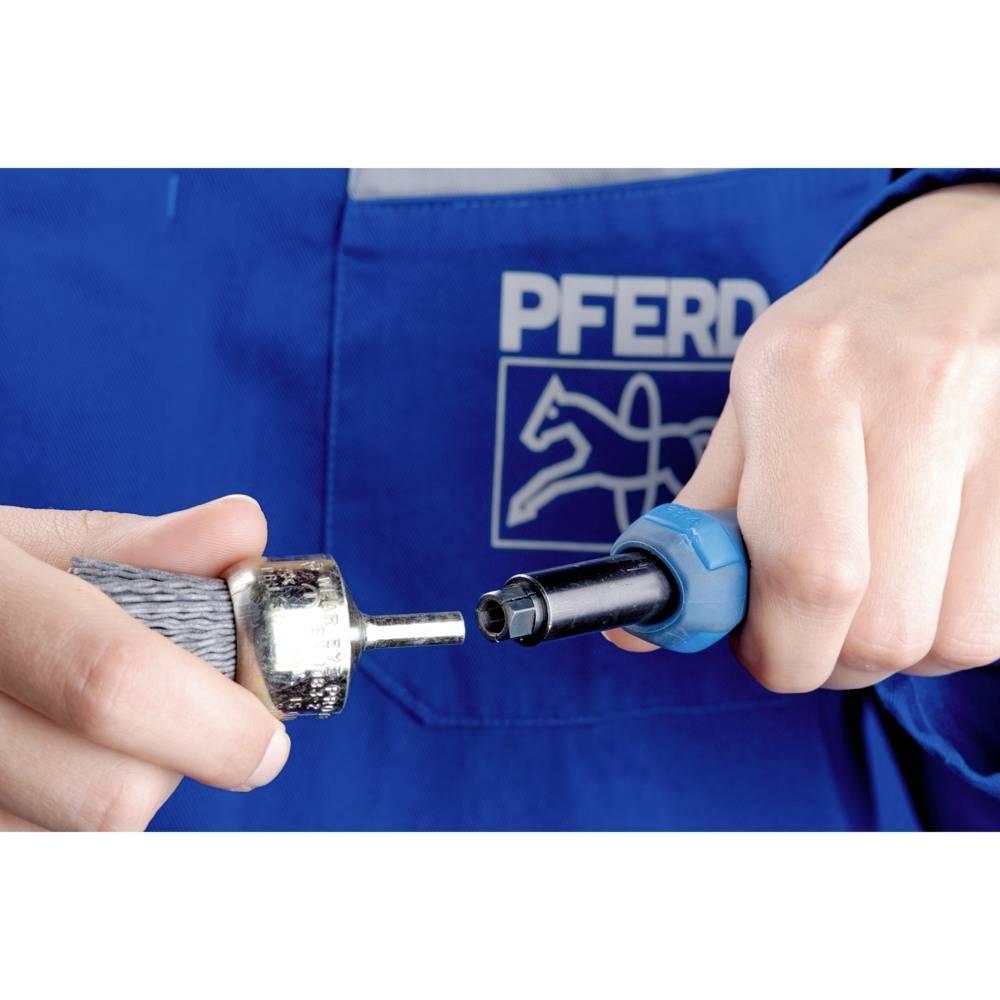 Två händer håller en verktygsdetalj och en adapter framför ett blått förkläde med logotypen 'PFERD'.