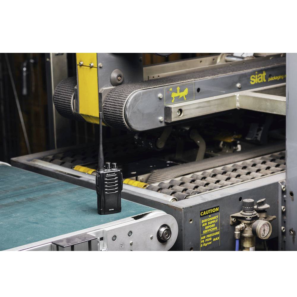 Radioenhet ligger på ett transportband bredvid en förpackningsmaskin.