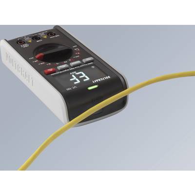 Ett digitalt multimeter visar en mätvärde på 33. En gul kabel löper över enheten.