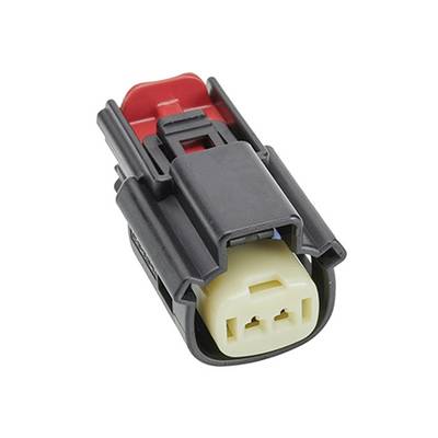 En svart och cremefärgad kontakt med ett rött clips, använd för elektriska anslutningar i fordonsapplikationer.